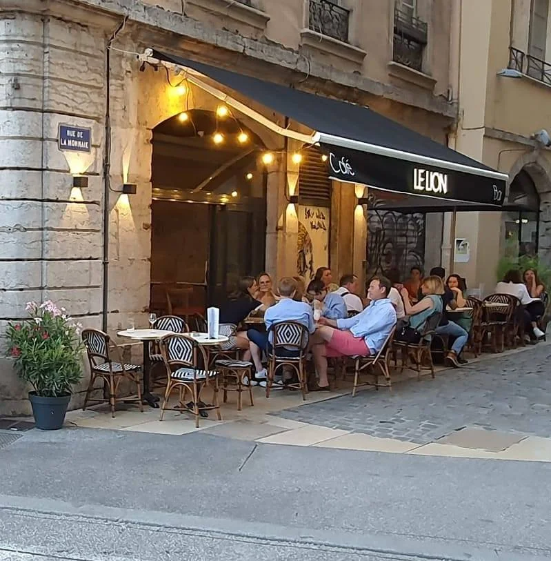 Intérieur du Lion Bar Lyon avec étagères à bouteilles et lumière chaude